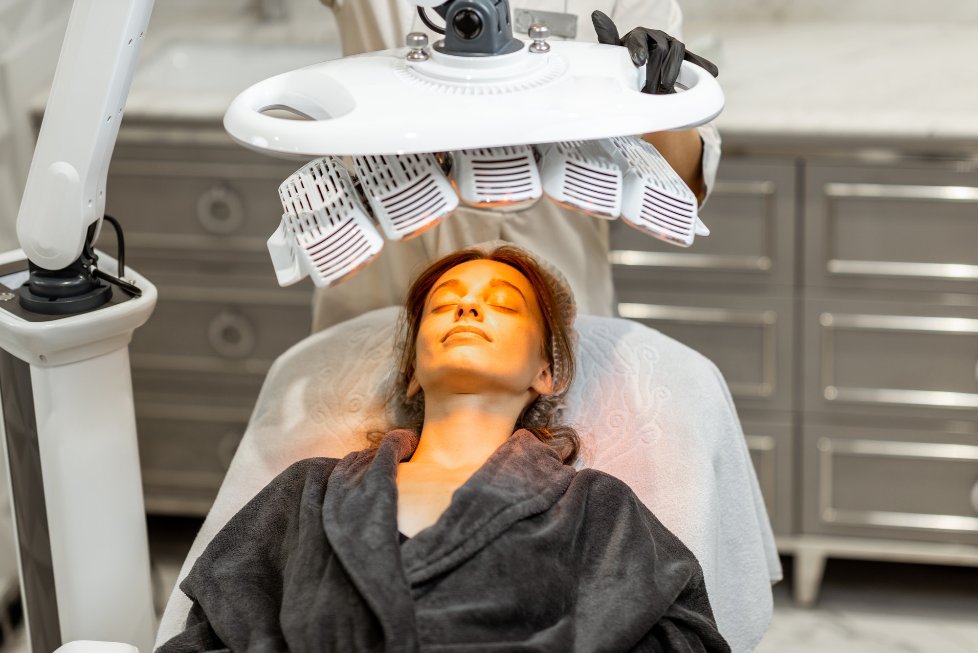 Woman during led light therapy at medical office